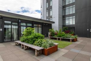 a courtyard with benches and plants in front of a building at Deluxe One Bedroom Apartment in Newmarket Auckland in Auckland