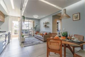 cocina y sala de estar con mesa y sofá en Requinte Floripa - Apartamento - Design Moderno en Florianópolis
