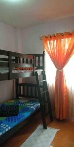 1 Schlafzimmer mit 2 Etagenbetten und einem Fenster in der Unterkunft Charming Getaway @ The City of Pines in Baguio City