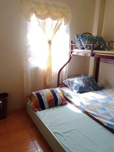 uma cama num quarto com uma janela e uma cama sidx sidx em Charming Getaway @ The City of Pines em Baguio