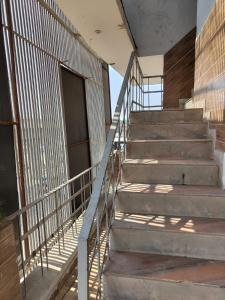 a set of stairs in a building with a metal fence at Metroview rooms & hotel in Bahādurgarh