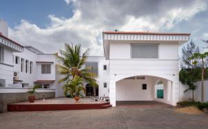 a white house with a courtyard and a palm tree at Nyali Villa in Mombasa