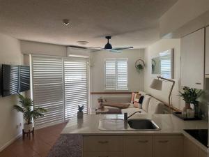 a kitchen with a sink and a living room with a couch at 2 Bedroom Central Mooloolaba Resort with Pool, Spa, Mini Golf in Mooloolaba
