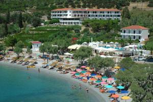 a beach with a bunch of umbrellas and people on it at Hotel Glicorisa Beach in Pythagoreio