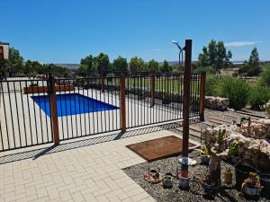 a fence with a pool in a yard at River Retreats Kalbarri in Kalbarri
