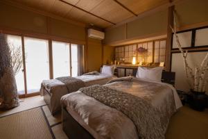 two beds in a room with windows at Azumino Salon in Azumino