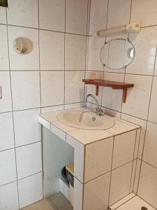uma casa de banho com um lavatório e um espelho em T3 Bel Enclos SCHOELCHER Kybo Karaib Location Vue mer Calme em Schœlcher