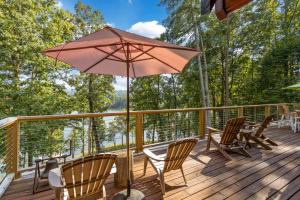 a patio with chairs and an umbrella on a deck at Lake Haven Lodge in Wilkesboro