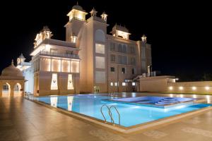 una grande piscina di fronte a un edificio di notte di The Utopia Resort Sanchi a Sānchi