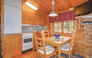 a kitchen with a table and chairs in a cabin at Beautiful Home In Storfors With Kitchen in Rådetorp