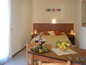 a room with a bed and a table with wine glasses at Villaggio Artemide in Giardini Naxos