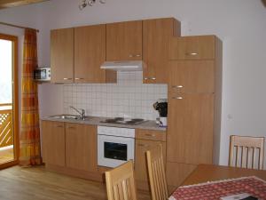 una cucina con armadi in legno e piano cottura. di Haus Neurauter a Niederthai