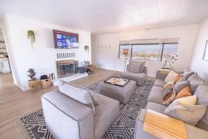 a living room with a couch and chairs and a fireplace at By Park Entrance, Hot Tub, Stars, Private ܍ WKNDR in Twentynine Palms
