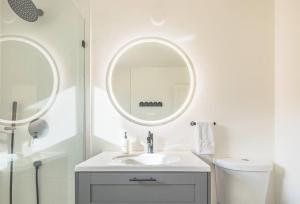 a white bathroom with a sink and a mirror at By Park Entrance, Hot Tub, Stars, Private ܍ WKNDR in Twentynine Palms +22 photos