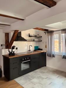 a kitchen with black cabinets and a sink at Grich Witch apartment in Zagreb