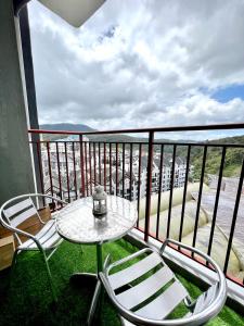 una mesa y sillas en un balcón con vistas en 3R3B, 500m to Centrum Brinchang, en Cameron Highlands