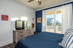 een slaapkamer met een bed, een tv en een raam bij Long Call by Oak Island Accommodations in Oak Island