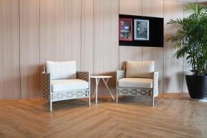 2 sillas y una mesa en una habitación en Roxy Hotel Aiman en Kuching