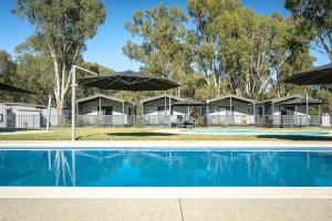 a resort with a swimming pool and umbrellas at Ingenia Holidays Murray Bend in Koonoomoo