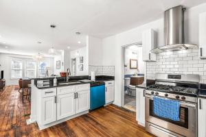 uma grande cozinha com armários brancos e electrodomésticos azuis em Modern 2 Bedroom Apartment Free Parking em Detroit