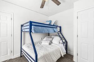 Modern 2 Bedroom Apartment Free Parking في ديترويت: سرير أزرق بطابقين في غرفة بجدران بيضاء