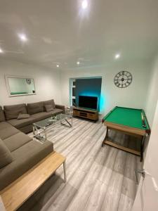a living room with a couch and a pool table at 5 Bed Town House Within City Centre and Sleeps Up To 11 with Sky and Netflix in Birmingham