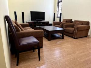 - un salon avec un canapé, une table et une télévision dans l'établissement SpaciousLuxury 4BR Seksyen 7/UITM Shah Alam/I-City, à Shah Alam