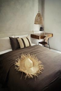 a bed with a straw hat on top of it at Banyan Villa Panglao with private pool in Panglao