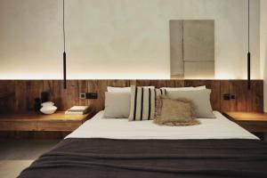 1 dormitorio con 1 cama grande con sábanas y almohadas blancas en Banyan Villa Panglao with private pool, en Panglao