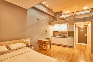 a bedroom with a bed and a table and a kitchen at Provista Hotel in Seoul