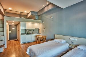 a large room with two beds and a kitchen at Provista Hotel in Seoul