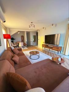 sala de estar con sofá marrón y TV de pantalla plana en Dreamy Sea View Duplex in Izmit, en Izmit