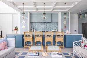 a kitchen with blue cabinets and a table and chairs at Umbala the house in Canggu