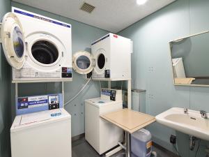 ein Krankenhauszimmer mit einer Waschmaschine und einem Waschbecken in der Unterkunft New Sunpia Tsuruga in Tsuruga