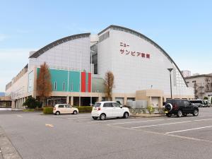 ein Gebäude mit Autos auf einem Parkplatz in der Unterkunft New Sunpia Tsuruga in Tsuruga