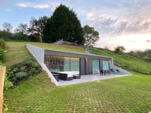 a modern house on top of a grassy hill at La Casa de Hierba - Casa de campo de diseño con jardín y wifi cerca de las playas de Llanes in Llanes