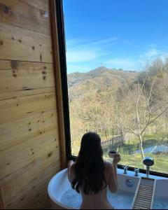 a woman sitting in a tub looking out of a window at Algreco Naturists & Swinging in Asgourou