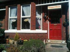 a red brick house with a red door at Prospect House in Whitby