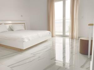 um quarto branco com uma cama e piso em azulejo em Blue Dream Afytos em Afitos