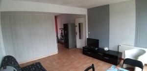 ein Wohnzimmer mit Sofa und TV in einem Zimmer in der Unterkunft Maison 2 chambres, terrasse/jardin (proche PARIS) in Argenteuil