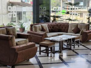 a living room with a couch and a table at Hotel Preethi International in Mysore
