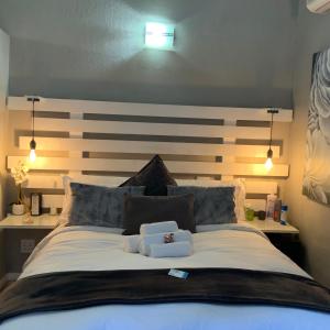 um quarto com uma cama grande e uma cabeceira em madeira em Meraki Upmarket Guesthouse em Rustenburg