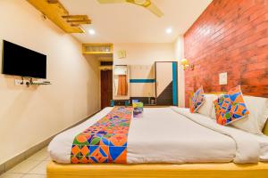 維沙卡帕特南的住宿－FabHotel Kinnera Comforts Railway Station，一间卧室设有一张大床和墙壁