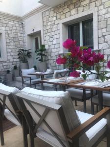 patio ze stołami i krzesłami z kwiatami w wazie w obiekcie KOTRABA ALAÇATI BUTİK Hotel w mieście Alaçatı