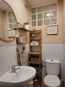 a bathroom with a sink and a toilet and a mirror at "COZY LOFT", TERRACE, PARKING and SWIMMING POOL in Málaga