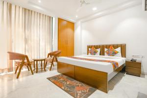 a bedroom with a bed and a table and chairs at FabExpress Aerosky Deluxe in New Delhi