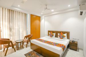 新德里的住宿－FabExpress Aerosky Deluxe，卧室配有一张床和一张桌子及椅子