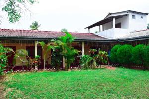 a house with a green lawn in front of it at Beach Walk Villa in Trincomalee