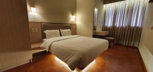 een slaapkamer met een groot wit bed en een raam bij The Nisha Continental in Kottayam