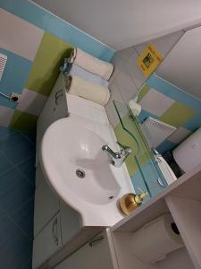 La salle de bains est pourvue d'un lavabo blanc et de serviettes. dans l'établissement Zidanica Meglič - Vineyard cottage Meglič, à Trebnje